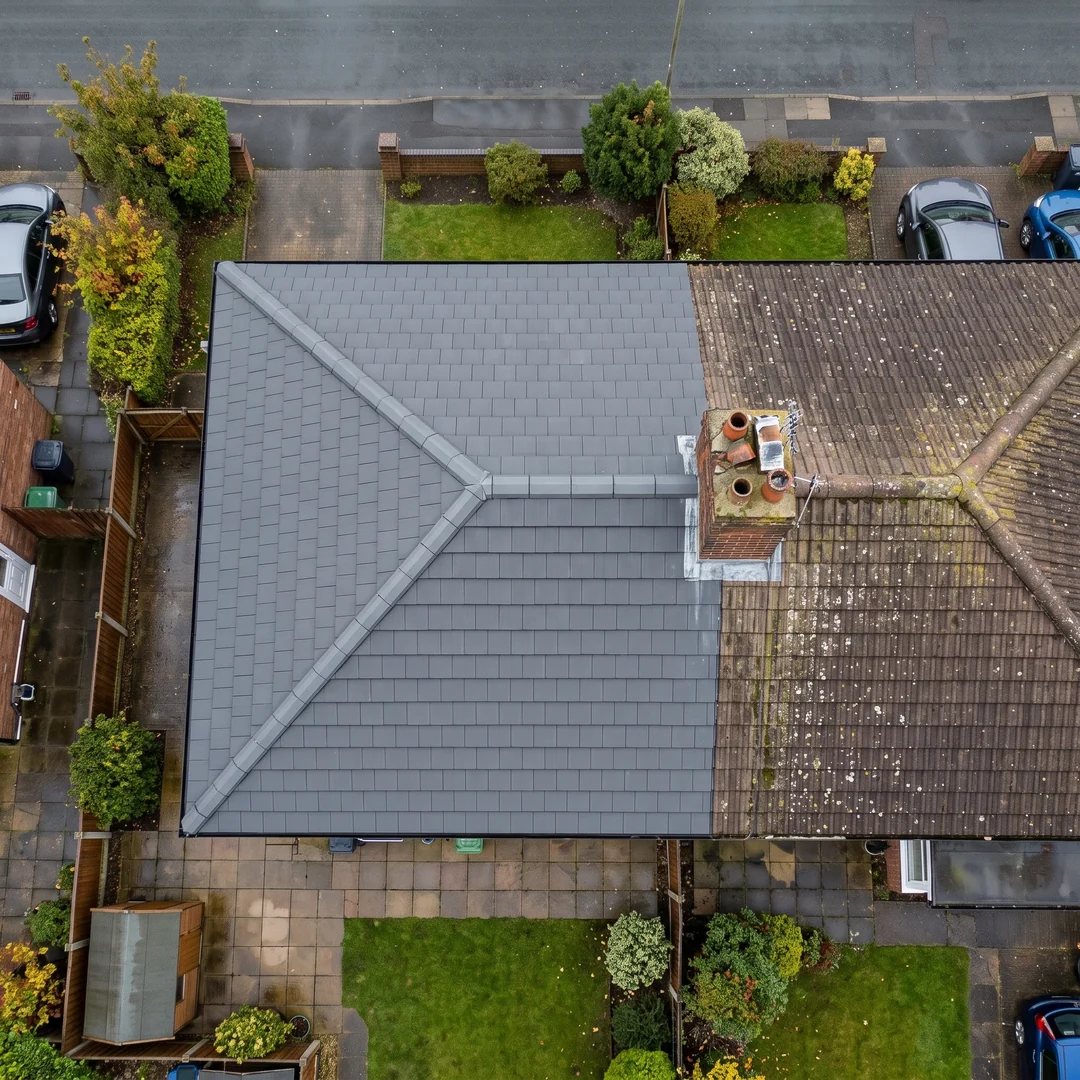 Top-down drone view of a new grey tiled hip roof